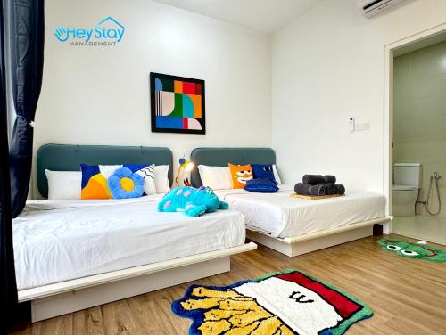 two beds sitting in a room with a rug at The Apple Residence By Heystay Management in Melaka