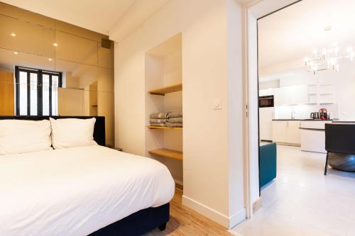 une chambre avec un grand lit et une cuisine dans l'établissement Loft 1 BR jardin des plantes AC by LCC Agency, à Paris