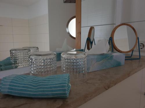 a counter with glasses and a mirror in a bathroom at Ferienhof Elbauenblick in Radebeul