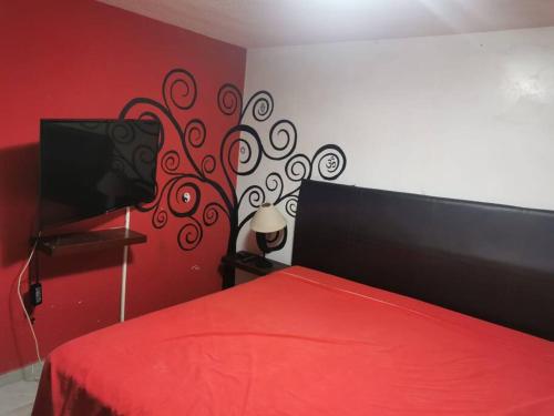 a bedroom with a red bed with a red bedspread at Rento casa por día, semana o mes in San Juan Xilotzingo