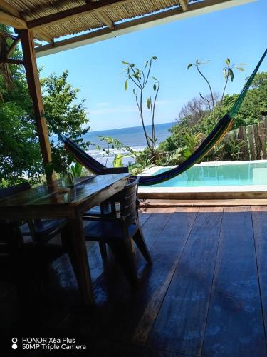 a hammock on a deck with a view of the ocean at Surf Lodge El Carrizal-Punta Mango in La Periquera
