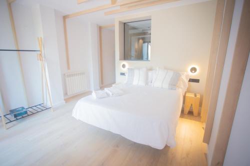 a bedroom with a large white bed with white pillows at L'indret del Pedraforca Adults Only in Saldés