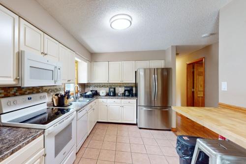 a kitchen with white cabinets and a stainless steel refrigerator at Hawthorne Hideaway in Pocono Summit