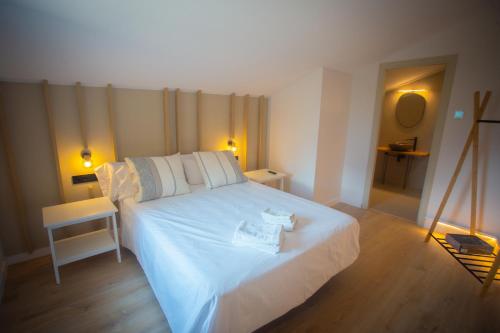 a bedroom with a large white bed with two towels on it at L'indret del Pedraforca Adults Only in Saldés