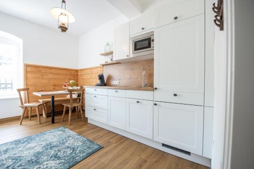 a kitchen with white cabinets and a dining table at Leopold an der Ybbs in Waidhofen an der Ybbs