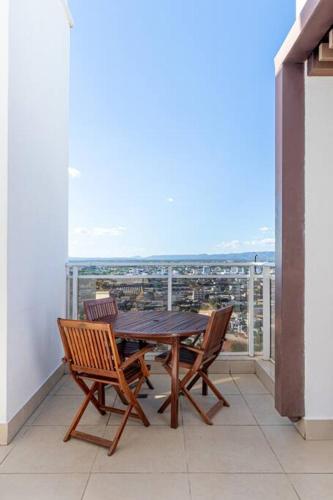 a table and chairs on a balcony with a view at PALMAS EXPERIENCE - APARTAMENTO BRISA, no centro, vista lago! in Palmas