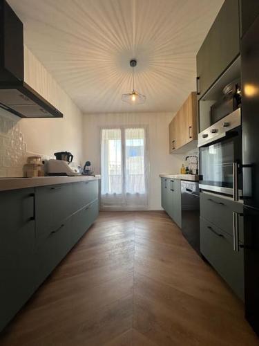 Il comprend une grande cuisine dotée de parquet et d'une grande fenêtre. dans l'établissement Appartement - 90m 2 - Blois, à Blois