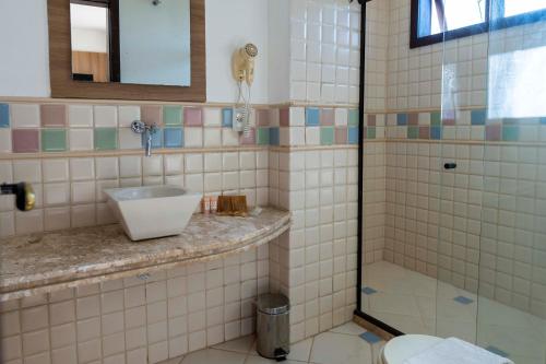 a bathroom with a sink and a shower at Costa do Sol Boutique Hotel in Búzios