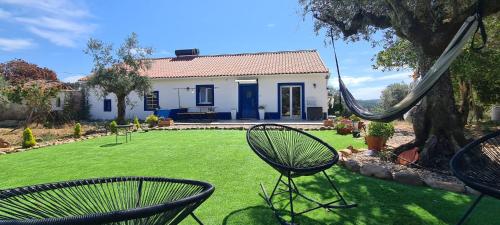 a yard with two chairs and a house at Cantinho da paz Peacefull Haven in Abrantes