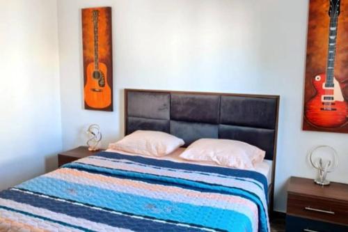 a bedroom with a bed with two guitars on the wall at Luxury Getaway3 - Brand New 2BR in Sharm El Sheikh