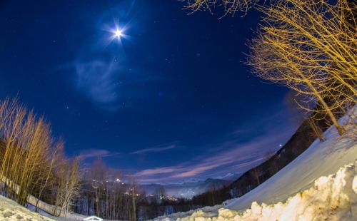 a night time view of a snow covered field with the moon at Il Borgo Dei Celti in Fiumalbo