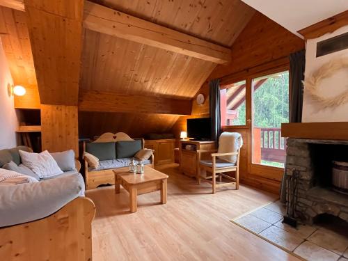 un salon avec un canapé et une cheminée dans l'établissement Ski in & out spacious apartment, Sauna-Gym-Piscine, à Oz