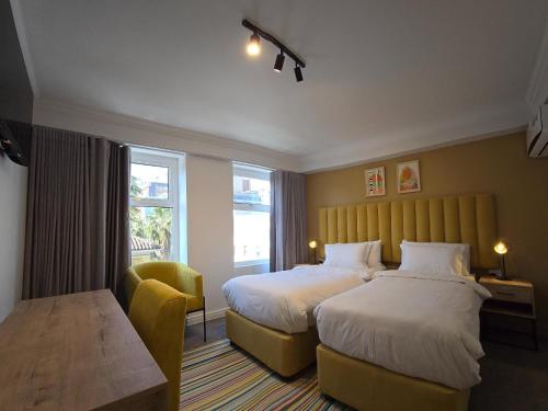 a hotel room with two beds and a table at 9 On Barrack in Cape Town