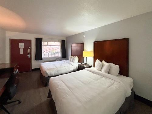 una camera d'albergo con due letti e una scrivania di Motel 6 Mesa, AZ - Downtown a Mesa
