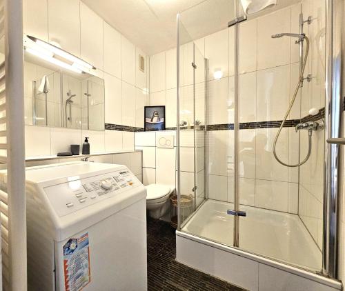 ein weißes Badezimmer mit Dusche und Toilette in der Unterkunft Lovely City House in Meerbusch