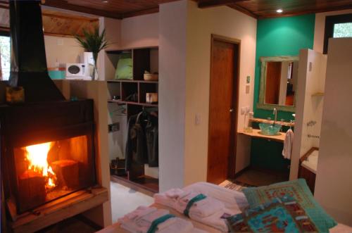a room with a fireplace and a bed in front of it at Chai Thale in Mar de las Pampas