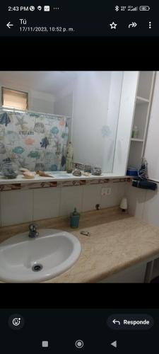 a bathroom with a sink and a mirror at Frente al Mar vista Panorámica Tomé in Tomé