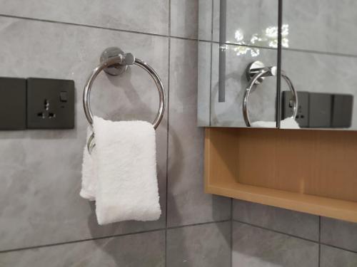a towel hanging on a towel rack in a bathroom at Soft Life Crib in Lavington - Dine, Wine & Relax in Nairobi