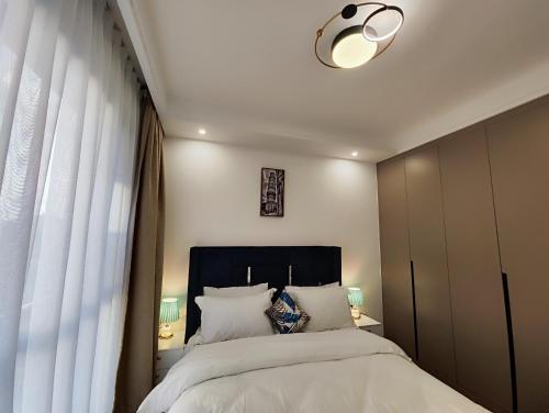 a bedroom with a large bed with a black headboard at Soft Life Crib in Lavington - Dine, Wine & Relax in Nairobi
