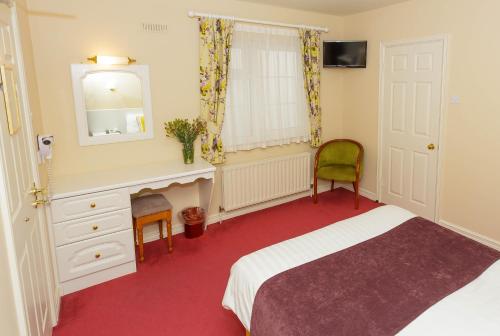 a bedroom with a bed and a mirror and a chair at Ashville House in Killarney