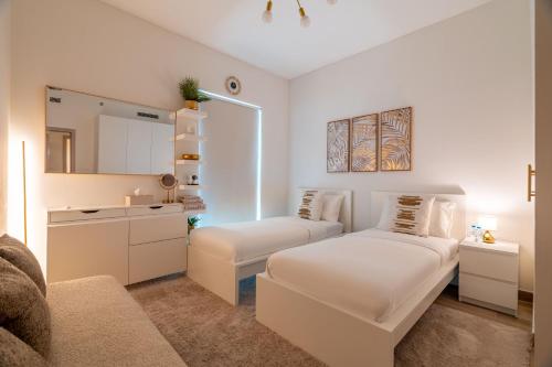 a white room with a bed and a mirror at Yas Pearl - 2BD by SLV in Abu Dhabi