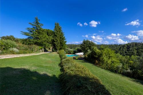 a hedge in front of a yard with a swimming pool at Villa Elisabetta in Trequanda