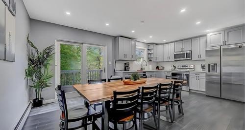 a kitchen with a wooden table and chairs at Peaceful Pocono Home with Hot Tub, gym, & office in Long Pond