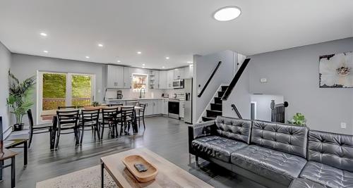 a living room and kitchen with a couch and a table at Peaceful Pocono Home with Hot Tub, gym, & office in Long Pond