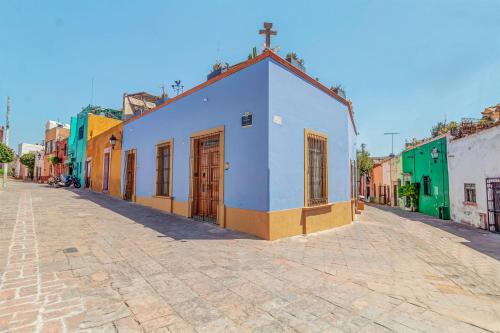 a street with a blue building on a cobblestone street at Suite en Centro Historico Terraza, Wifi, Desk, AC in Querétaro