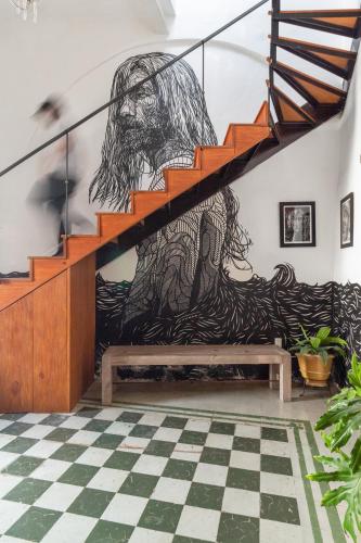 a mural in a room with a bench and stairs at Suite en Centro Historico Terraza, Wifi, Desk, AC in Querétaro