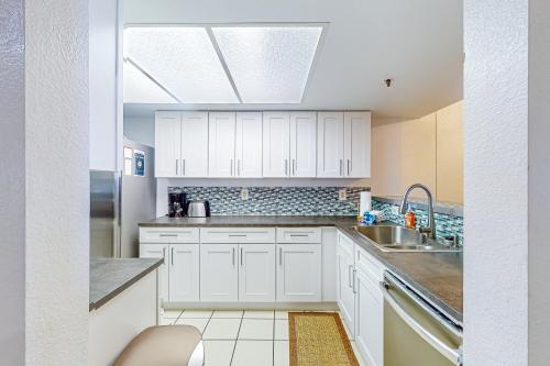 a kitchen with white cabinets and a sink at The Bridges 102 in Mammoth Lakes