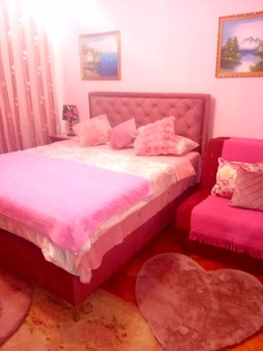 a bedroom with a bed with pink sheets and a heart pillow at Guest House Cinderella in Herceg-Novi