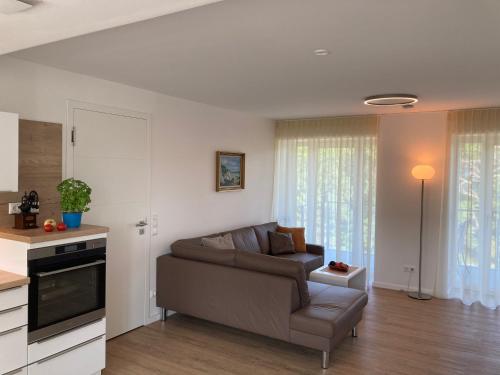 ein Wohnzimmer mit Couch und Küche in der Unterkunft Dünenwelle - 3 Zi, Kü, 2 Bäder, Balkon in Binz