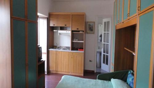 a kitchen with wooden cabinets and a living room at La Terrazza di Spello in Spello