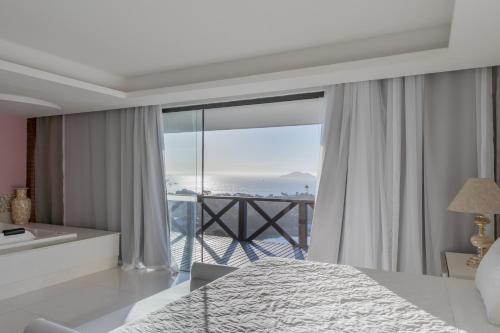a bedroom with a bed and a view of the ocean at Costa do Sol Boutique Hotel in Búzios