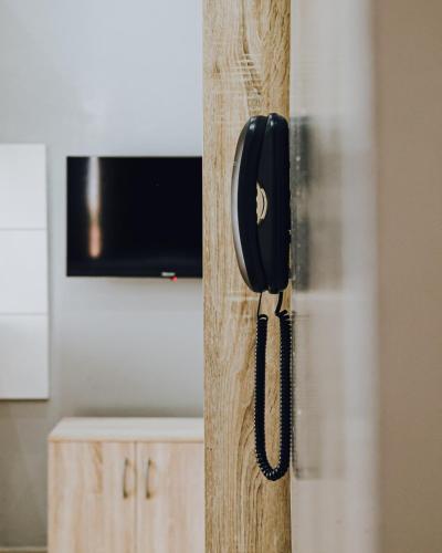 a black phone hanging on the side of a door at La RESIDENCE LES HIBISCUS in Djoungolo