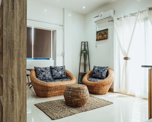 a living room with two wicker chairs and a window at La RESIDENCE LES HIBISCUS in Djoungolo