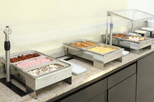 a buffet line with trays of different types of food at Holiday Inn Express Ciudad Del Carmen by IHG in Ciudad del Carmen