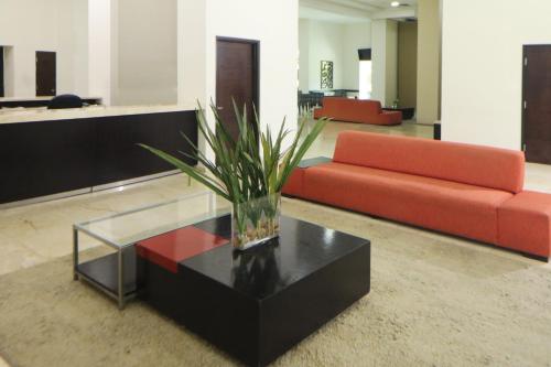 a living room with a red couch and a glass table at Holiday Inn Express Ciudad Del Carmen by IHG in Ciudad del Carmen