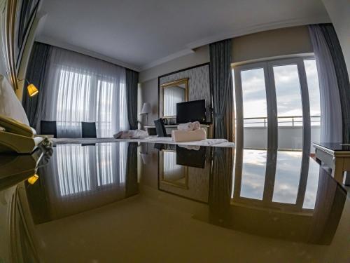 a hotel room with a large window and a desk at Asr-ı Ala Yalova Thermal in Gokcedere