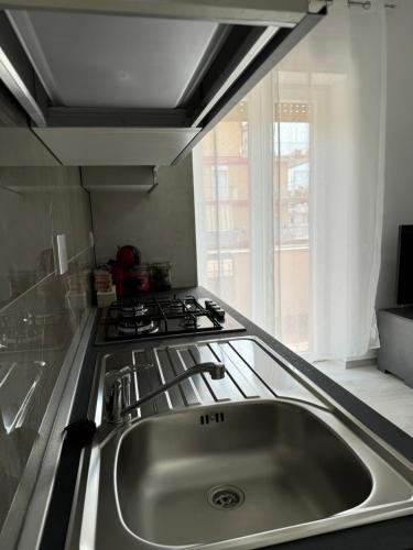 una cocina con fregadero y estufa en Eco del Mare, en Ladispoli
