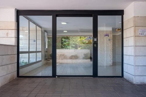 an entrance to a building with glass doors at Ashdod Skyview modern 3bdr apartment by torohome in Ashdod