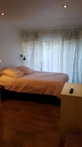 - une chambre avec un lit et des rideaux blancs dans l'établissement villa piscine proche des plages, à Marsillargues