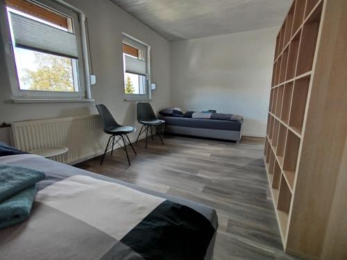 a bedroom with a bed and a couch and two chairs at Ferienwohnung Harz in Ballenstedt in Ballenstedt