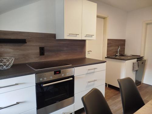 a kitchen with white cabinets and a stove top oven at Ferienwohnung Harz in Ballenstedt in Ballenstedt