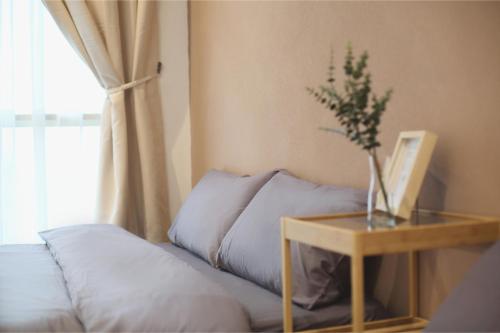 a bed with a table next to a window at Afiniti 2BR Scandinavian Escape - Legoland 300m in Iskandar Puteri