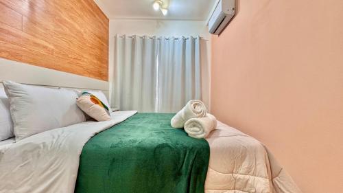 a bedroom with a bed with towels on it at Sky Batel - Apartamentos UROOMS in Curitiba