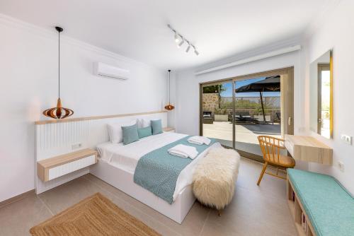 a white bedroom with a bed and a balcony at Villa Casa Che in Kalkan