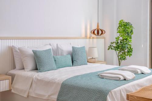 a white bed with blue and white pillows on it at Villa Casa Che in Kalkan