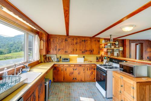 a kitchen with wooden cabinets and a large window at Hawley Home with Deck and Mtn Views Swim, Ski and More! in Hawley